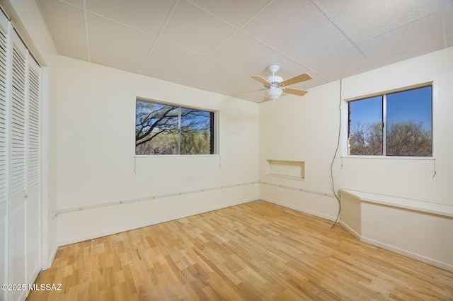 6532 N Cibola Ave, Tucson, AZ 85718 - unfurnished bedroom with a paneled ceiling, wood finished floors, baseboards, a closet, and a ceiling fan