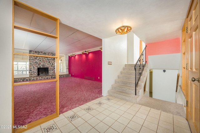 6532 N Cibola Ave, Tucson, AZ 85718 - unfurnished living room with carpet, a stone fireplace, stairs, and rail lighting