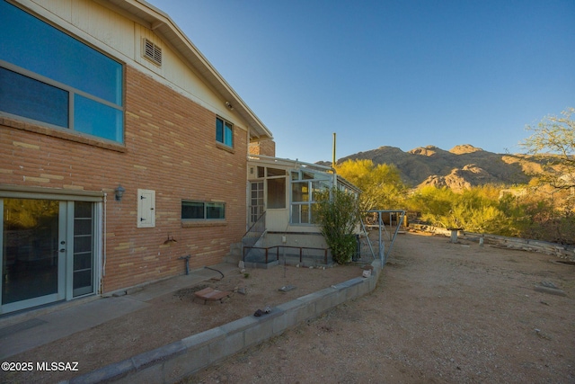6532 N Cibola Ave, Tucson, AZ 85718 - view of home's exterior with a sunroom, a mountain view, and brick siding
