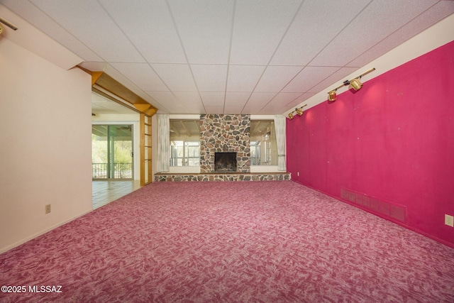 6532 N Cibola Ave, Tucson, AZ 85718 - unfurnished living room with carpet floors, a stone fireplace, and rail lighting