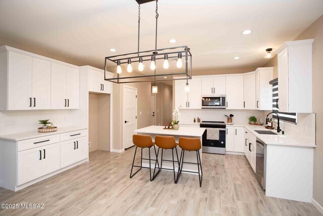 3601 E Nebraska Stra, Tucson, AZ 85706 - kitchen with stainless steel appliances, a kitchen island, white cabinets, a kitchen breakfast bar, and recessed lighting