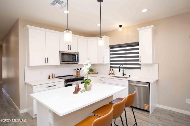 3601 E Nebraska Stra, Tucson, AZ 85706 - kitchen with stainless steel appliances, a center island, light countertops, decorative backsplash, and white cabinetry