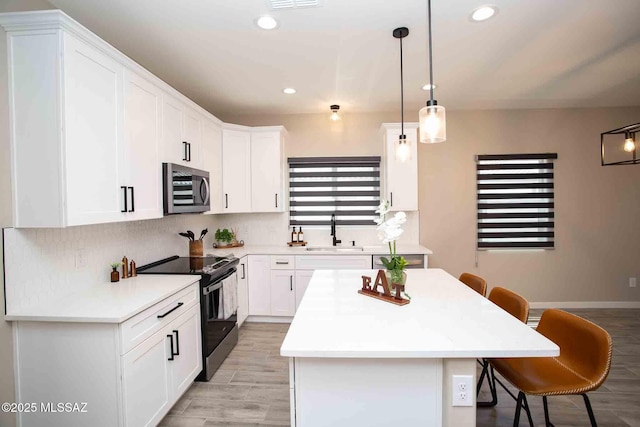 3601 E Nebraska Stra, Tucson, AZ 85706 - kitchen with electric stove, stainless steel microwave, a breakfast bar, a kitchen island, and light countertops