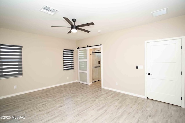 3601 E Nebraska Stra, Tucson, AZ 85706 - unfurnished bedroom featuring a barn door, light wood-style floors, fridge, and ceiling fan
