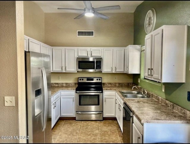 1643 W Houchin Way, Tucson, AZ 85746 - kitchen featuring stainless steel appliances, a ceiling fan, white cabinets, light tile patterned floors, and a textured wall