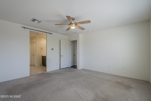 662 N Tree Mist Ln, Sahuarita, AZ 85629 - unfurnished bedroom with light carpet, ensuite bath, a ceiling fan, and baseboards