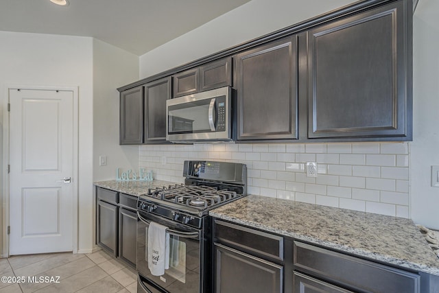 662 N Tree Mist Ln, Sahuarita, AZ 85629 - kitchen featuring stainless steel microwave, black range with gas stovetop, light stone countertops, and tasteful backsplash