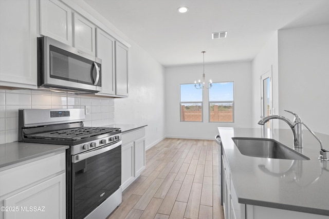 12767 E Giada Dr, Vail, AZ 85641 - kitchen with appliances with stainless steel finishes, a sink, a chandelier, baseboards, and decorative backsplash