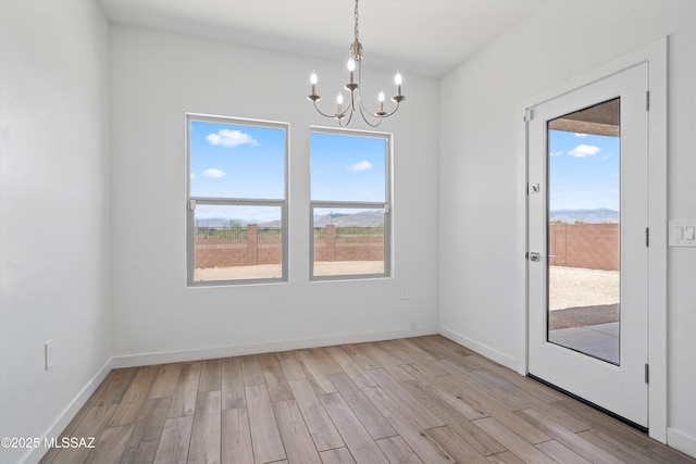 12767 E Giada Dr, Vail, AZ 85641 - unfurnished dining area with a chandelier, healthy amount of natural light, light wood-style flooring, and baseboards