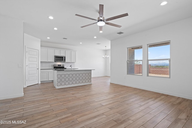 12767 E Giada Dr, Vail, AZ 85641 - unfurnished living room with recessed lighting, a ceiling fan, a chandelier, light wood-style flooring, and baseboards