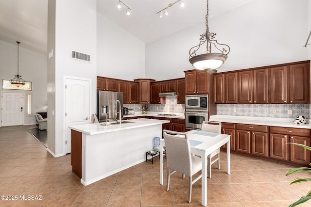 7397 W Crimson Ridge Dr, Marana, AZ 85743 - kitchen with high vaulted ceiling, appliances with stainless steel finishes, tasteful backsplash, light tile patterned floors, and light countertops