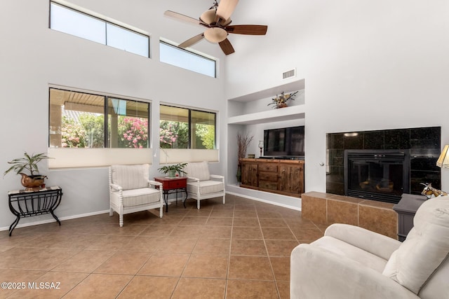 7397 W Crimson Ridge Dr, Marana, AZ 85743 - tiled living area featuring a ceiling fan, a towering ceiling, and a tile fireplace