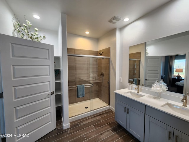 14139 E Canidae Dr E, Vail, AZ 85641 - ensuite bathroom featuring double vanity, a shower stall, wood finished floors, and recessed lighting
