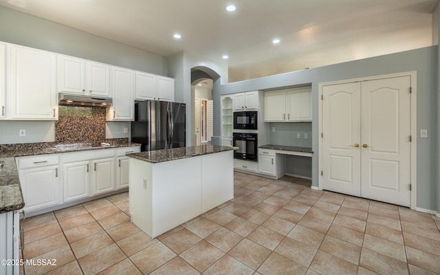 8892 N Silver Moon Way, Tucson, AZ 85743 - kitchen with black appliances, under cabinet range hood, arched walkways, a kitchen island, and tasteful backsplash
