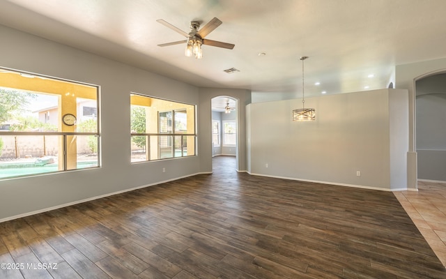 8892 N Silver Moon Way, Tucson, AZ 85743 - empty room featuring ceiling fan, arched walkways, dark wood-style floors, and recessed lighting