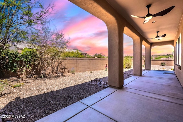 3259 E Corte Doce Palomas, Tucson, AZ 85718 - patio terrace at dusk with a ceiling fan, a patio, and a fenced backyard