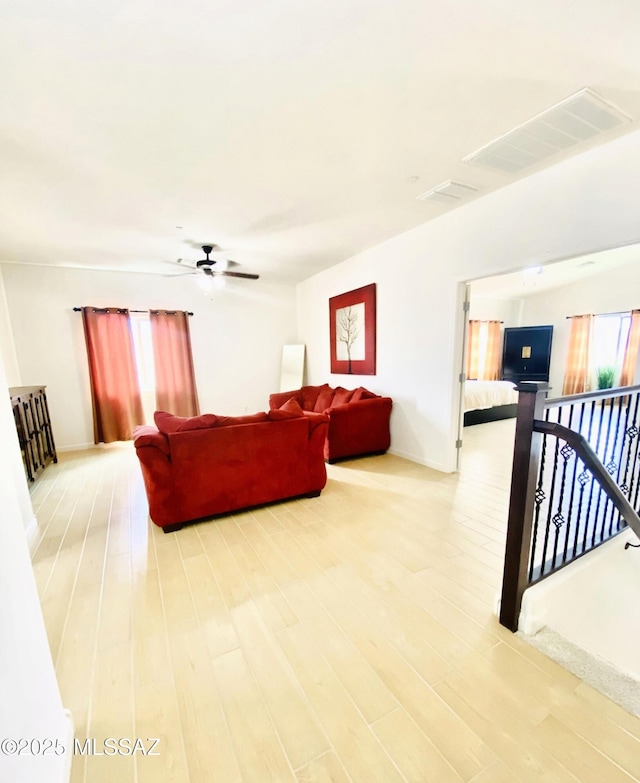 9828 N Niobrara Way, Tucson, AZ 85742 - living area featuring light wood finished floors, ceiling fan, and baseboards