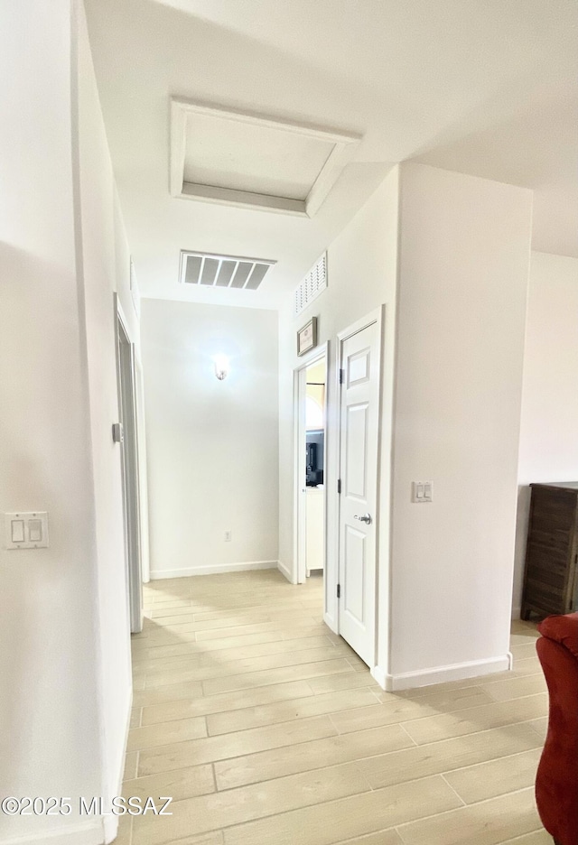 9828 N Niobrara Way, Tucson, AZ 85742 - hallway with light wood-style flooring, baseboards, and attic access