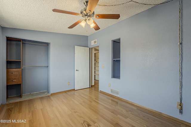 7821 N Jensen Dr, Tucson, AZ 85741 - unfurnished bedroom with wood finished floors, a closet, a textured ceiling, and ceiling fan