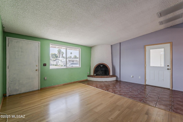 7821 N Jensen Dr, Tucson, AZ 85741 - unfurnished living room with wood finished floors, a fireplace, and a textured ceiling