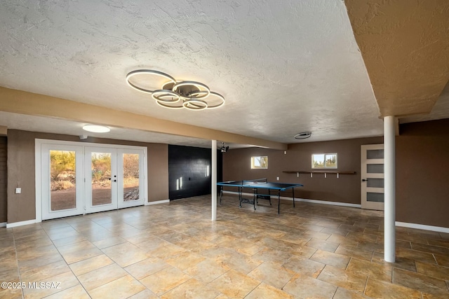 4939 E River Rd, Tucson, AZ 85718 - recreation room featuring baseboards, a textured ceiling, french doors, and stone finish floors