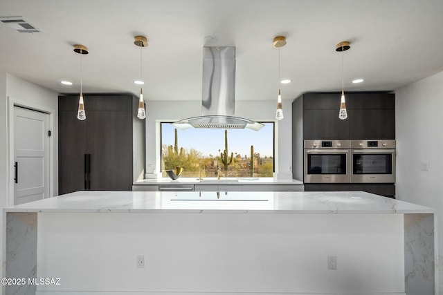 4939 E River Rd, Tucson, AZ 85718 - kitchen with island range hood, light stone counters, hanging light fixtures, double oven, and a center island