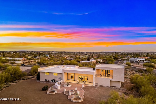 4939 E River Rd, Tucson, AZ 85718 - back of house at dusk featuring stucco siding and a patio area