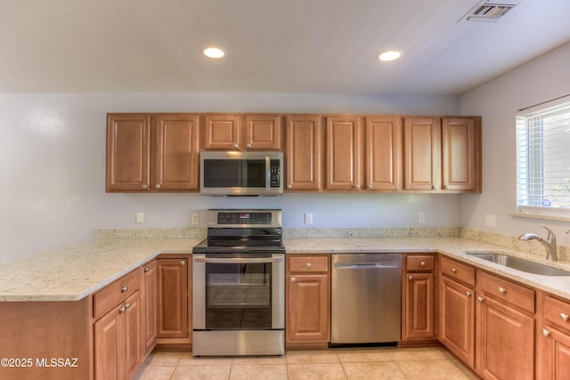 6255 N Camino Pimeria Alta Apt 65, Tucson, AZ 85718 - kitchen with appliances with stainless steel finishes, a sink, recessed lighting, light stone counters, and a peninsula