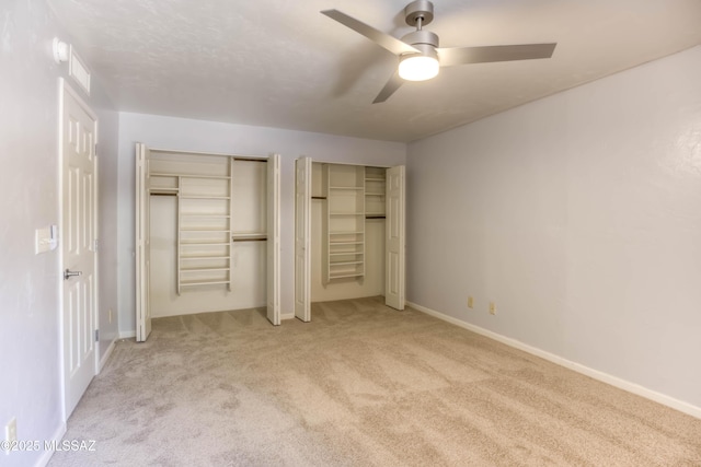 6255 N Camino Pimeria Alta Apt 65, Tucson, AZ 85718 - unfurnished bedroom featuring light carpet, two closets, a ceiling fan, and baseboards