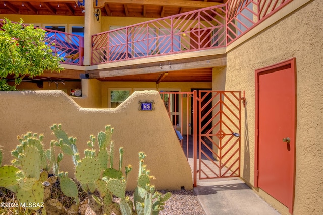 6255 N Camino Pimeria Alta Apt 65, Tucson, AZ 85718 - property entrance featuring a gate, stucco siding, and a balcony