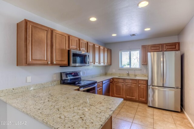 6255 N Camino Pimeria Alta Apt 65, Tucson, AZ 85718 - kitchen featuring stainless steel appliances, a peninsula, recessed lighting, brown cabinetry, and a sink