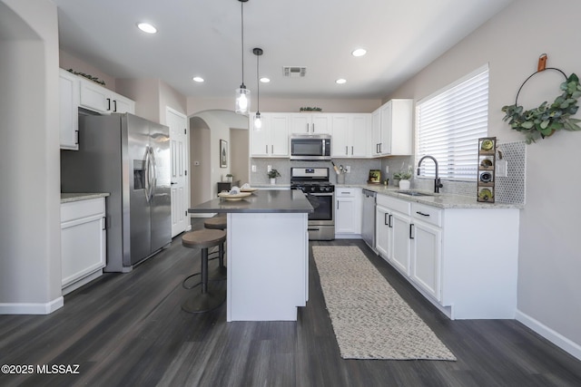 Tucson, AZ 85748 - kitchen with appliances with stainless steel finishes, a sink, arched walkways, dark wood finished floors, and white cabinets