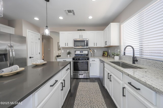 Tucson, AZ 85748 - kitchen featuring stainless steel appliances, a sink, arched walkways, white cabinetry, and recessed lighting