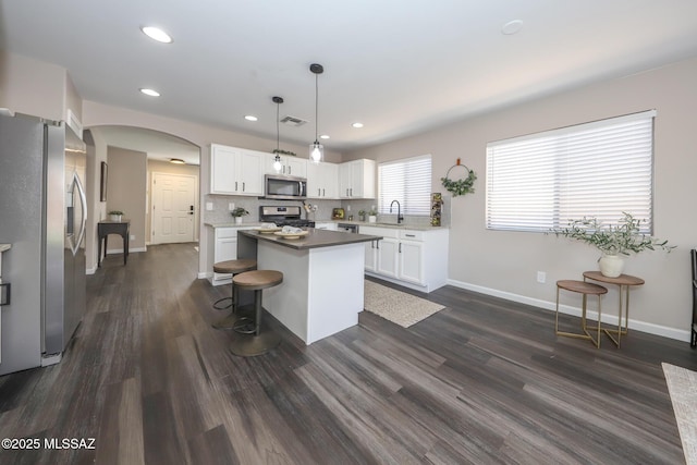 Tucson, AZ 85748 - kitchen featuring stainless steel appliances, a sink, arched walkways, white cabinets, and baseboards