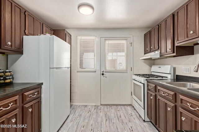 134 S Paseo Quinta Unit A, Green Valley, AZ 85614 - kitchen with white appliances, dark countertops, light wood-type flooring, and under cabinet range hood