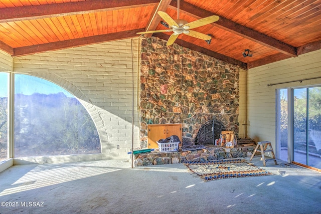 5730 N Tula Ln, Tucson, AZ 85743 - unfurnished living room featuring a wood stove, wood ceiling with exposed beams, a ceiling fan, carpet flooring, and high vaulted ceiling