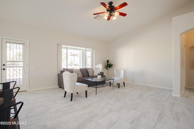 7663 W Creosote Spring Ct, Tucson, AZ 85743 - living area with healthy amount of natural light, arched walkways, a ceiling fan, and baseboards