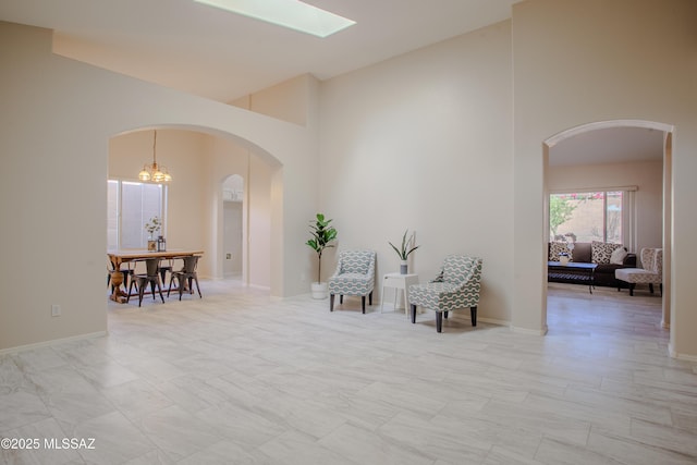 7663 W Creosote Spring Ct, Tucson, AZ 85743 - living area featuring high vaulted ceiling, arched walkways, a chandelier, and baseboards