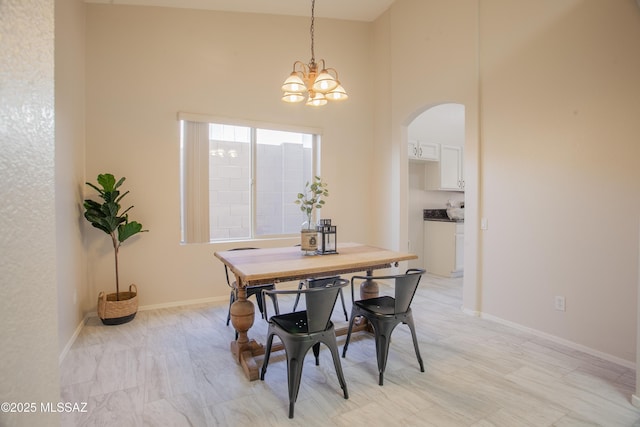 7663 W Creosote Spring Ct, Tucson, AZ 85743 - dining room with arched walkways, a chandelier, a towering ceiling, and baseboards