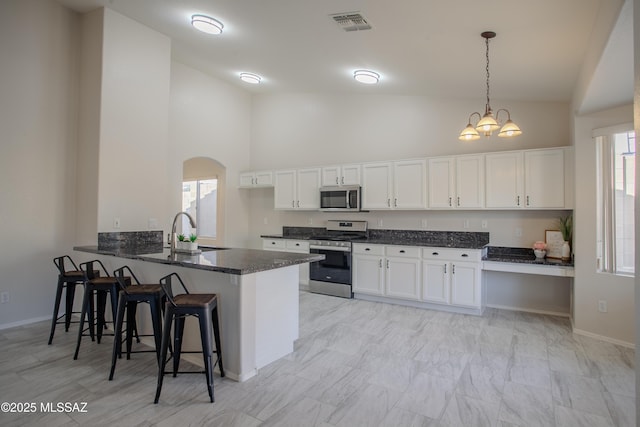 7663 W Creosote Spring Ct, Tucson, AZ 85743 - kitchen featuring stainless steel appliances, a sink, high vaulted ceiling, a peninsula, and white cabinetry