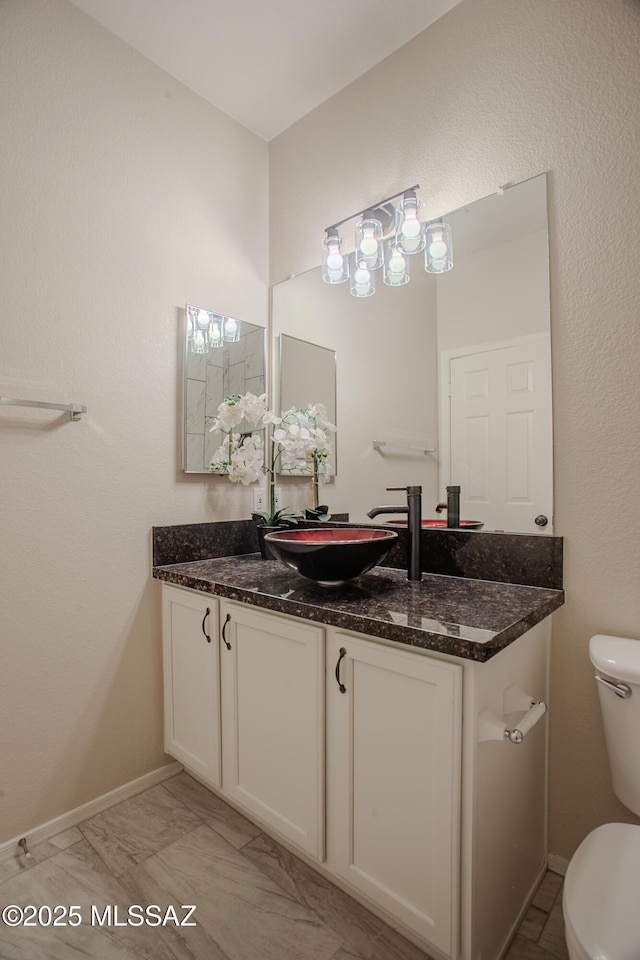 7663 W Creosote Spring Ct, Tucson, AZ 85743 - bathroom featuring toilet, vanity, baseboards, and marble look tile flooring