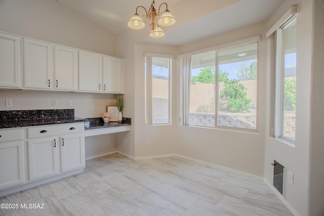 7663 W Creosote Spring Ct, Tucson, AZ 85743 - kitchen with a chandelier, white cabinets, dark stone countertops, healthy amount of natural light, and vaulted ceiling
