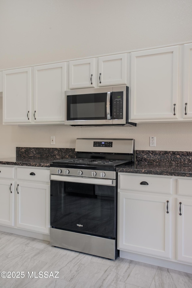 7663 W Creosote Spring Ct, Tucson, AZ 85743 - kitchen with stainless steel appliances, white cabinets, dark stone countertops, and light marble finish floors