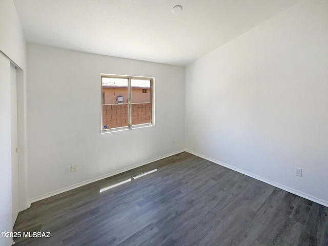 8233 E Sundew Dr, Tucson, AZ 85710 - unfurnished bedroom featuring dark wood-style flooring, a closet, and baseboards