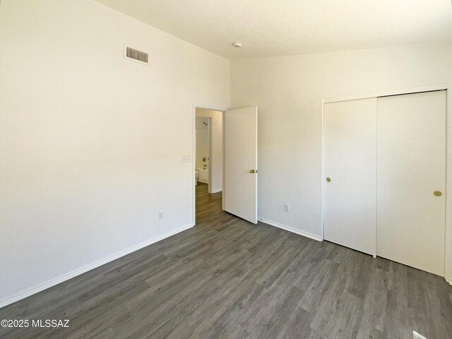 8233 E Sundew Dr, Tucson, AZ 85710 - unfurnished bedroom featuring wood finished floors, a closet, baseboards, and lofted ceiling