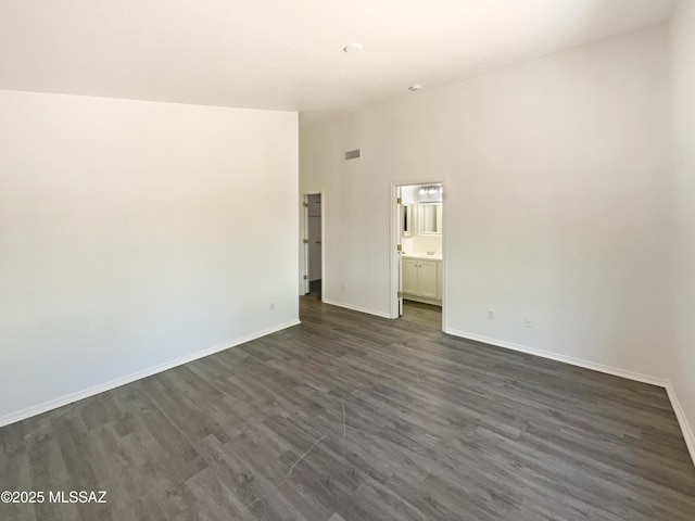 8233 E Sundew Dr, Tucson, AZ 85710 - spare room featuring baseboards, dark wood-type flooring, and high vaulted ceiling