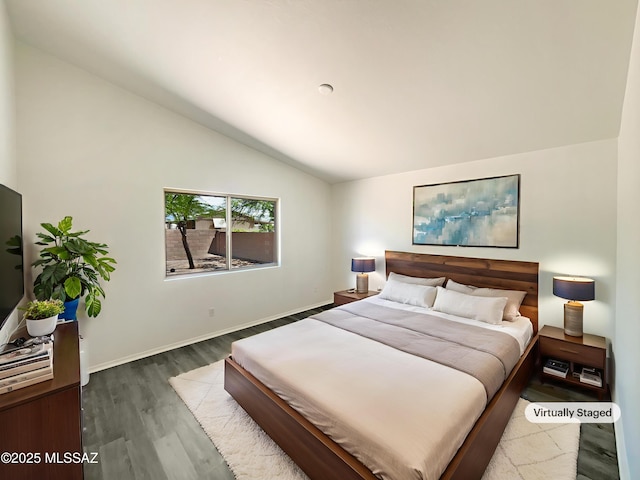 8233 E Sundew Dr, Tucson, AZ 85710 - bedroom featuring lofted ceiling, wood finished floors, and baseboards