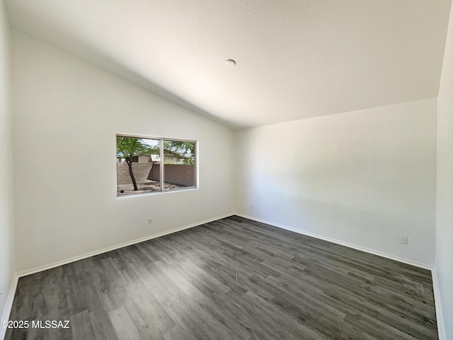 8233 E Sundew Dr, Tucson, AZ 85710 - empty room with lofted ceiling, dark wood-style flooring, and baseboards