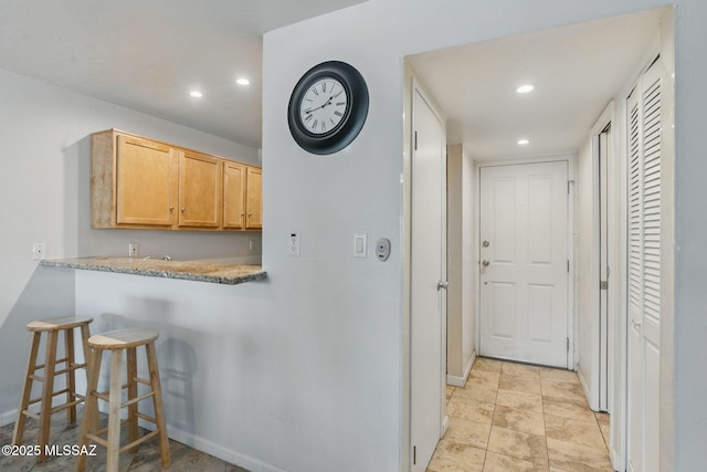 961 N Euclid Ave Unit 130, Tucson, AZ 85719 - kitchen featuring recessed lighting, light countertops, a kitchen breakfast bar, baseboards, and light brown cabinets