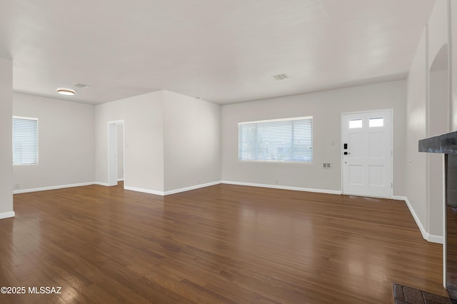 3001 E Helen St, Tucson, AZ 85716 - unfurnished living room featuring dark wood-style flooring and baseboards